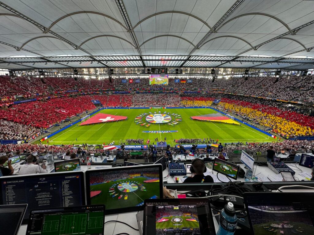 Vista aérea de un estadio abarrotado antes del partido Suiza-Alemania, con ordenadores portátiles preparados para el análisis en directo.