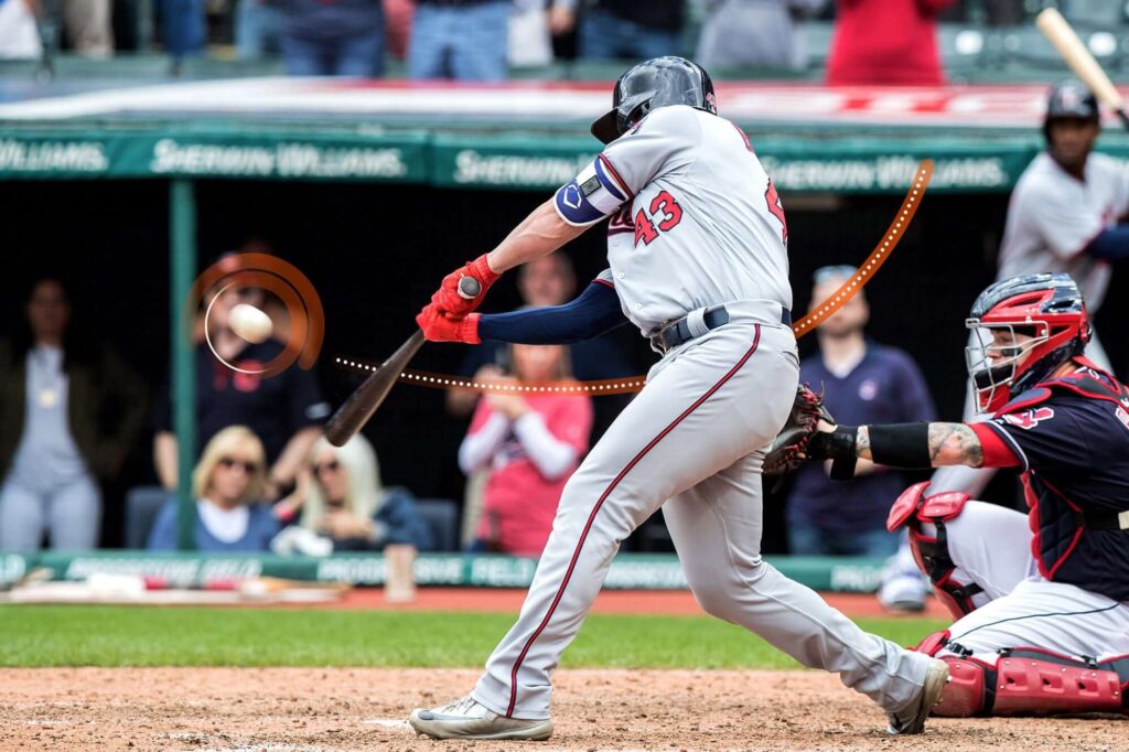 Baseballspieler mitten im Schwung, wobei Datenpunkte wie Schwungkraft und Beschleunigung zur performance erfasst werden.