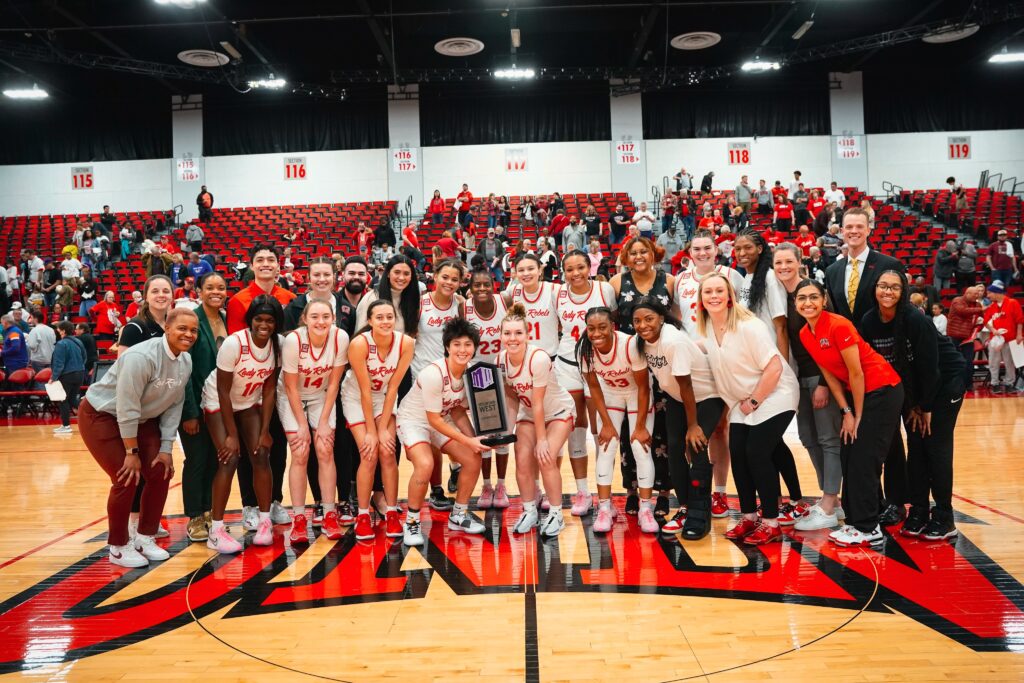 Đội bóng rổ nữ UNLV Lady Rebels tự hào tập trung trên sân, mỉm cười và tạo dáng với chiếc cúp vô địch, minh họa cho tinh thần đồng đội và thành công có thể đạt được thông qua việc sử dụng hiệu quả phân tích video và phát triển chiến lược.