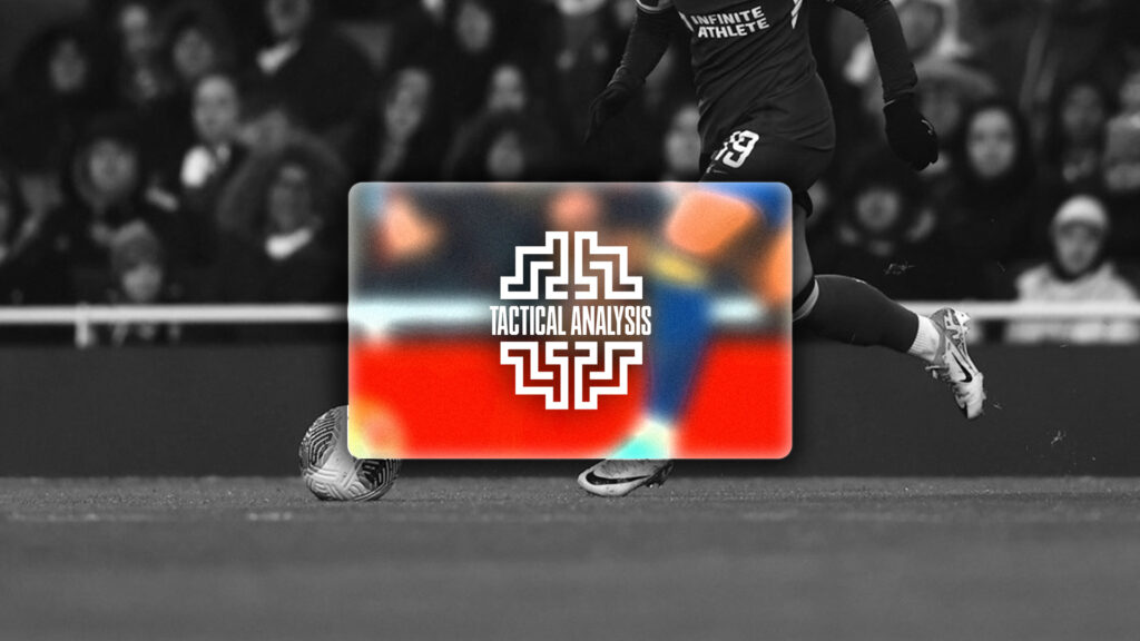 لاعب كرة قدم يرتدي زياً أسود وسترة منجنيق يركل كرة قدم في ملعب.